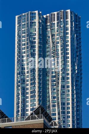 8 Spruce Street, auch bekannt als New York by Gehry, hat eine gewellte Wandfassade aus Edelstahl, die angeblich einen echten Vorhang imitiert. Stockfoto