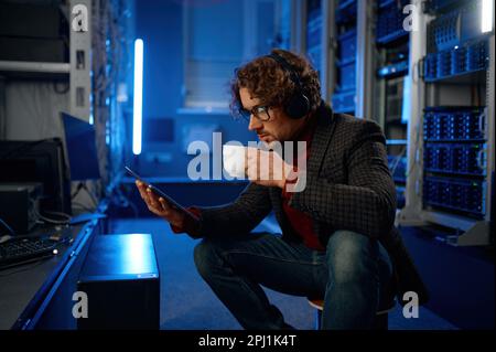 IT-Techniker, die ein digitales Tablet verwenden, während sie mit wichtigen Geräten arbeiten Stockfoto