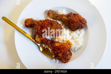 Gebratene Hähnchenschenkel (Unterschenkel) und weißer Reis Stockfoto