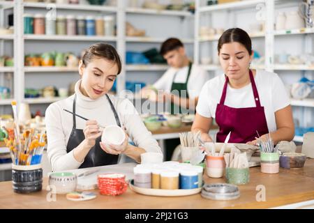 Zwei junge Frauen, die Töpferwaren in der Werkstatt herstellen Stockfoto