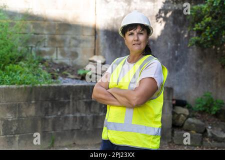 Reife Weibliche Industriearbeiterin. Straße, Baustelle, Abfall Stockfoto