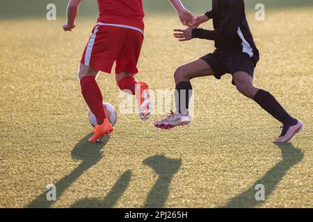 Bild von jungen Fußballspielern, die auf einem Fußballfeld mit dem Ball spielen Stockfoto