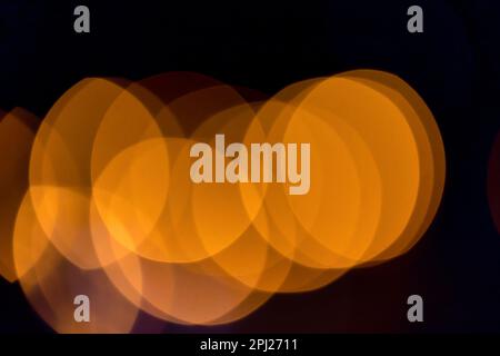 Abstraktes Hintergrundbild mit orangefarbenen Bokeh-Lichtern im Dunkeln Stockfoto