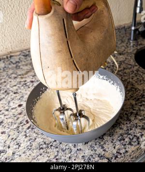 Elektrischer Mischer zur Zubereitung von Käsekuchen-Zutaten. Familiengastronomie. Stockfoto