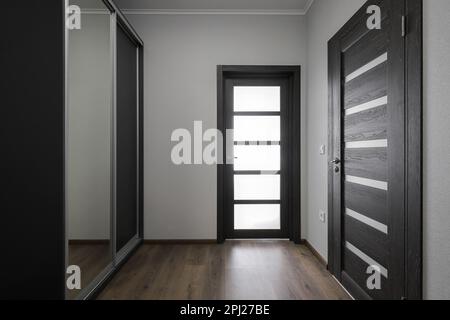 Dunkle Innentüren mit Glas im Apartment-Interieur Stockfoto