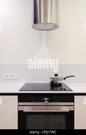 Bratpfanne auf einem elektrischen Induktionsherd in der Küche Stockfoto