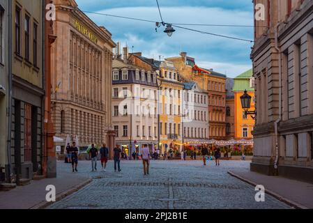 Riga, Lettland, 8. Juli 2022: Sonnenuntergang über Doma Laukums Platz voller Restaurants in der lettischen Hauptstadt Riga. Stockfoto