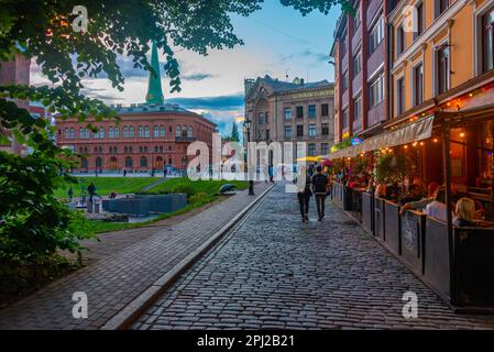 Riga, Lettland, 8. Juli 2022: Sonnenuntergang über Doma Laukums Platz voller Restaurants in der lettischen Hauptstadt Riga. Stockfoto