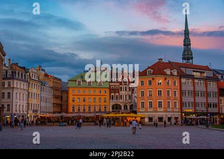 Riga, Lettland, 8. Juli 2022: Sonnenuntergang über Doma Laukums Platz voller Restaurants in der lettischen Hauptstadt Riga. Stockfoto