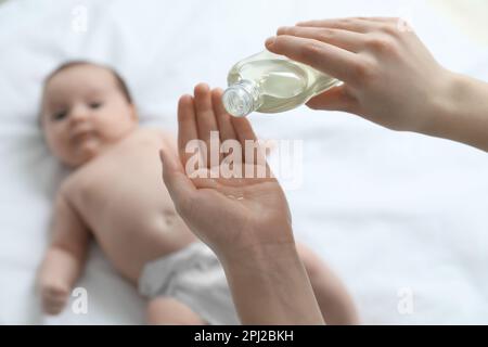 Mutter mit Massageöl in der Nähe ihres süßen Babys, Nahaufnahme Stockfoto