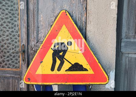 Verschiedene Verkehrsschilder in der Nähe der alten Holztür Stockfoto