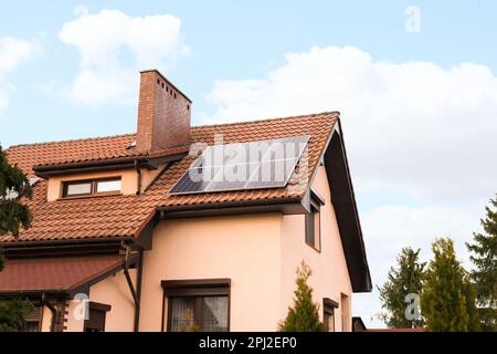 Haus mit installierten Sonnenkollektoren auf dem Dach. Alternative Energie Stockfoto