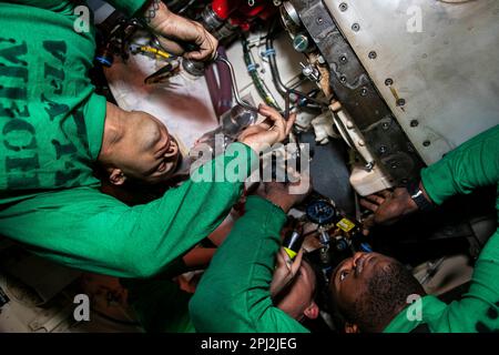 Adria. 25. Februar 2023. Aviation Machinists Mate Airman Kendal Cook, Left, Aviation Machinists Mate 3. Class James Barclift, Right, und Aviation Machinists Mate 1. Class David Carlile, alle dem Strike Fighter Squadron (VFA) 143 zugeteilt, führen Wartungsarbeiten an einem Luftturbinenstarter an Bord des Flugzeugträgers USS George H.W. der Nimitz-Klasse durch Bush (CVN 77) Kredit: USA Navy/ZUMA Press Wire Service/ZUMAPRESS.com/Alamy Live News Stockfoto