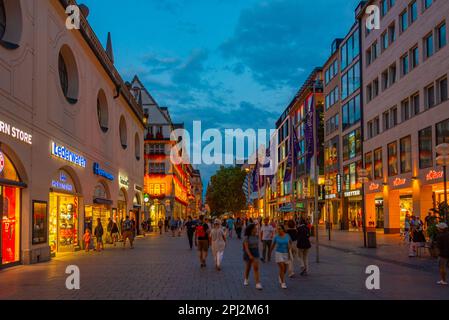 München, Deutschland, 15. August 2022: Sonnenuntergang über einer Handelsstraße in der deutschen Stadt München. Stockfoto