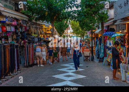 Agios Nikolaos, Griechenland, 19. August 2022: Sonnenuntergang über Menschen, die auf einer Touristenstraße in der griechischen Stadt Agios Nikolaos auf Kreta spazieren. Stockfoto