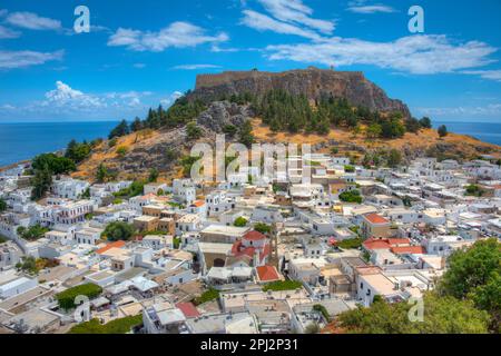 Lindos, Griechenland, 25. August 2022: Akropolis von Lindos mit Blick auf traditionelle weiße Häuser auf der Insel Rhodos, Griechenland. Stockfoto