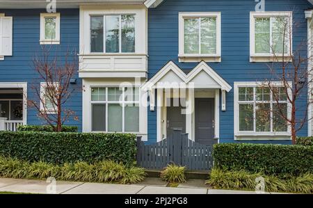 Wunderschönes brandneues zeitgenössisches Haus in einer kanadischen Nachbarschaft. Eingangstüren mit hübscher Veranda und Garten. Moderner Hauseingang. Vordertür mit Stockfoto