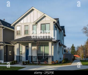 Häuser in einem Vorort im Sommer in Nordamerika. Luxushäuser mit schöner Landschaft. Häuser und Straßen in einer wunderschönen Wohngegend. Niemand. Stockfoto