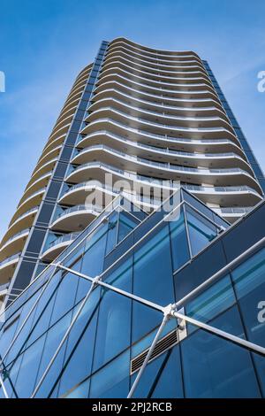 Ein Hochhaus am blauen Himmel. Wohnungs- oder Apartmentgebäude. Man Blickt Auf Das Blaue Moderne Gebäude. Architektur im modernen Gebäude GLA Stockfoto