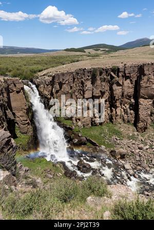 North Clear Creek Falls mit einem Regenbogen vom Wassernebel. Die Wasserfälle sind ein beliebtes Touristenziel von Creede Colorado. Stockfoto