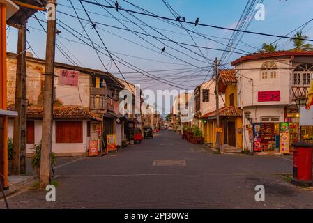 Galle, Sri Lanka, 21. Januar 2022: Sonnenaufgang über einer engen Straße der Altstadt von Galle, Sri Lanka. Stockfoto