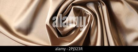 Hintergrund aus beigefarbenem Satin-Stoff. Textur aus Viskose ist brauner Hintergrund Stockfoto