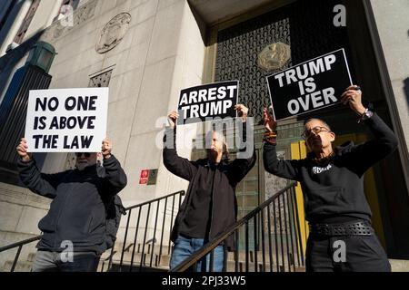 Anti-Trump-Demonstranten halten Schilder vor dem Manhattan Strafgericht in Vorbereitung einer möglichen Donald-Trump-Anklage. Stockfoto