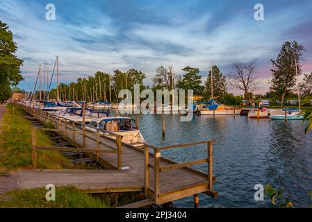 Vadstena, Schweden, 16. Juli 2022: Sonnenuntergang über dem Jachthafen in der schwedischen Stadt Vadstena. Stockfoto