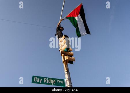 Die Palästinenser nehmen an einem Nakba-tagesmarsch Teil, bei dem einige Flaggen auf Straßenmasten in Bay Ridge, Brooklyn, schwenken Stockfoto