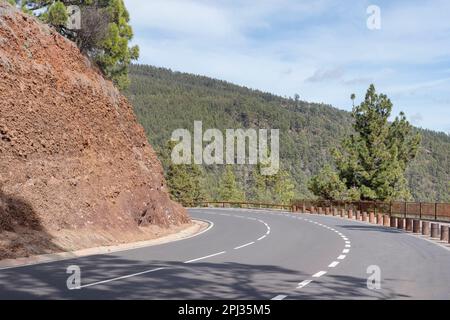 Gewundene Straße durch die Berge und Hügel bedeckt mit dem Pinienwald, bekannt als Corona Forestal des Teide Nationalparks, Teneriffa, Spanien Stockfoto