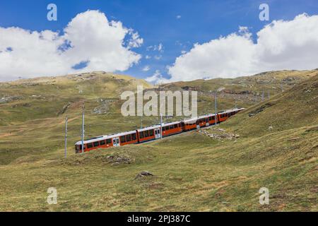 Roter Zug auf dem Hintergrund des Matterhorns in den Schweizer Alpen Stockfoto