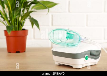 Vernebler mit Maske auf dem Tisch mit Kopierbereich. Stockfoto