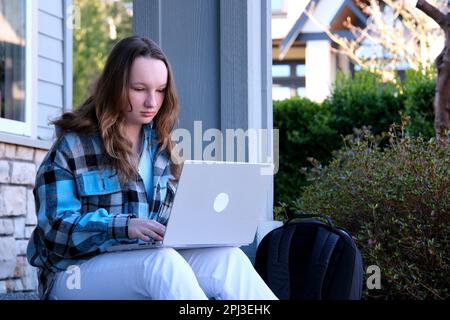 Mädchen lernt online mit einem Lehrer über das Internet auf einem Laptop mit Kopfhörer, Portrai von Frauen, die mit einem Freund über Studien sprechen. Konzept des Online-Lernens zu Hause. Hohe Qualität Stockfoto