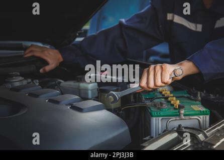 Der Mechaniker arbeitet am Motor des Autos in der Garage, Autoreparaturdienst. Stockfoto