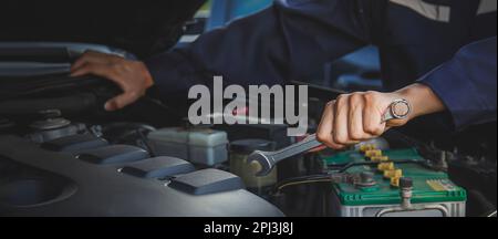 Der Mechaniker arbeitet am Motor des Autos in der Garage, Autoreparaturdienst. Stockfoto