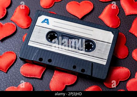 Alte Tonbandkassette auf einem verstreuten Red Hearts Nahaufnahme Stockfoto