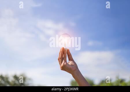 Hand halten Glühbirne, natürliche Energie und Liebe die Welt Konzept. Stockfoto