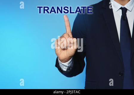 Ein Mann, der auf ein virtuelles Wortmodell zeigt. ÜBERSETZUNG vor türkisfarbenem Hintergrund, Nahaufnahme Stockfoto