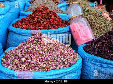 Stapel getrockneter Rosen und anderer Blumen, die als natürliche Düfte verwendet werden, werden auf dem Souk - dem traditionellen Straßenmarkt in Marokko - präsentiert Stockfoto