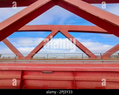 Rote Stahlbrücke namens Hanzeboog über den Fluss IJssel zwischen Hattem und Zwolle in den Niederlanden Stockfoto