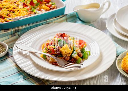 pinto Beans Speck Maisbrotsalat mit Tomaten, Paprika, Mais und Cheddar Käse auf einem Teller aus weißem Holz, horizontale Ansicht von oben, Nahaufnahme Stockfoto