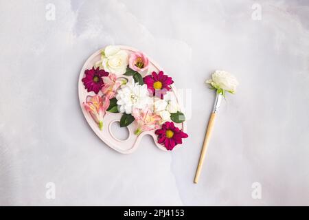 Blumen im Farbpalettenpinsel mit einer Blume auf grauem Untergrund Stockfoto