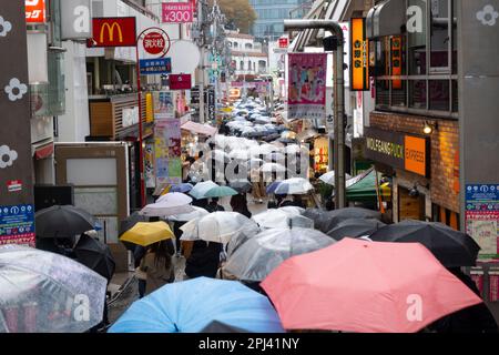 Sehen Sie die Takeshita Street mit vielen Sonnenschirmen im Regen in Harajuku, Tokio, Japan Stockfoto