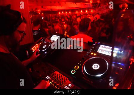 München, Deutschland. 27. Januar 2023. DJ Stefan dreht in der 089 Bar in München unter roter Beleuchtung kräftige Rhythmen tief in die Nacht. Kredit: Felix Hörhager/dpa/Alamy Live News Stockfoto