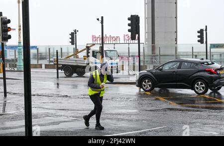 Brighton UK, 31. März 2023 - Es ist harte Arbeit, heute früh am Morgen an der Küste von Brighton entlang zu laufen, während die Südküste heute von Stürmen heimgesucht wird, wobei in einigen Gegenden Windgeschwindigkeiten von 70mph km prognostiziert werden : Credit Simon Dack / Alamy Live News Stockfoto