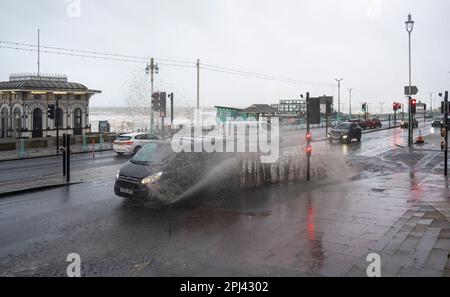 Brighton UK, 31. März 2023 - die Fahrer fahren heute Morgen durch die überflutete Brighton-Küstenstraße, während Storm Mathis die Südküste mit Windgeschwindigkeiten von 70mph in einigen Gebieten besiegt: Credit Simon Dack / Alamy Live News Stockfoto