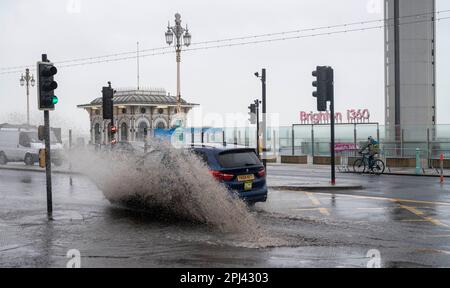 Brighton UK, 31. März 2023 - die Fahrer fahren heute Morgen durch die überflutete Brighton-Küstenstraße, während Storm Mathis die Südküste mit Windgeschwindigkeiten von 70mph in einigen Gebieten besiegt: Credit Simon Dack / Alamy Live News Stockfoto