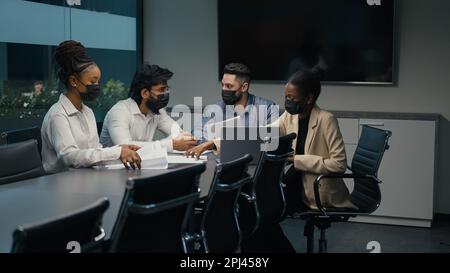 Multiethnische, vielfältige Business-Team-Partner Büroangestellte afroamerikanische indisch-arabische Kollegen in medizinischen Masken arbeiten zusammen diskutieren Startup Stockfoto