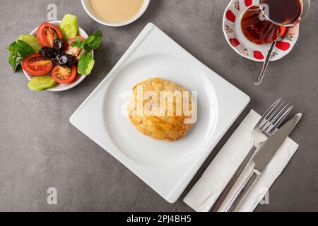 Izmir Boyoz auf einer weißen Porzellanplatte auf einem Steintisch Stockfoto