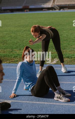 Ein blondes Mädchen trainiert, während ihre Freunde eine Pause machen Stockfoto